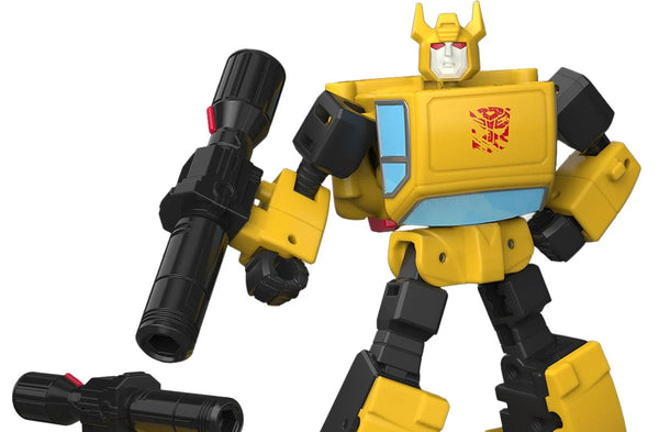 A yellow and black toy robot figure with a red Autobot-style emblem on the chest, holding a large black gun-like accessory, shown beside a small matching yellow car with a mounted black gun on top, all on a plain white background.