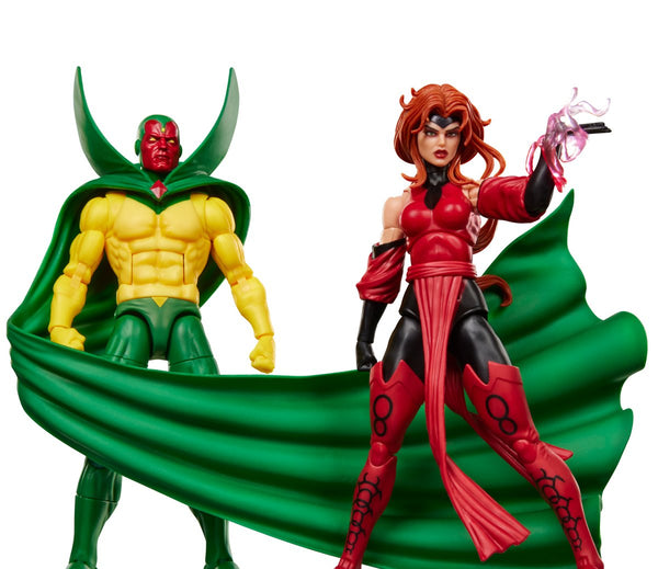 Marvel Legends action figure set featuring Vision and Scarlet Witch on a clean white background. Vision stands on the left in his classic yellow and green armor with a green cape, while Scarlet Witch stands on the right in her red and black costume with a flowing green cape and pink energy effect in her hand.